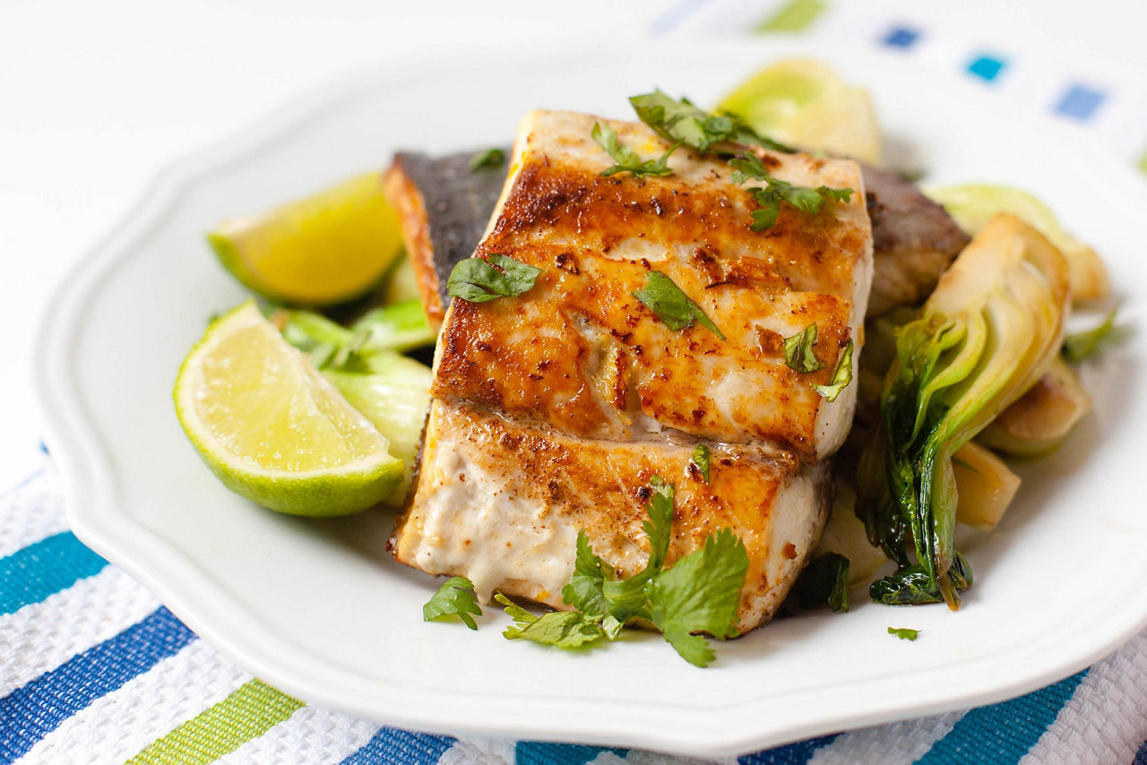 A pan seared fish filet on a white plate