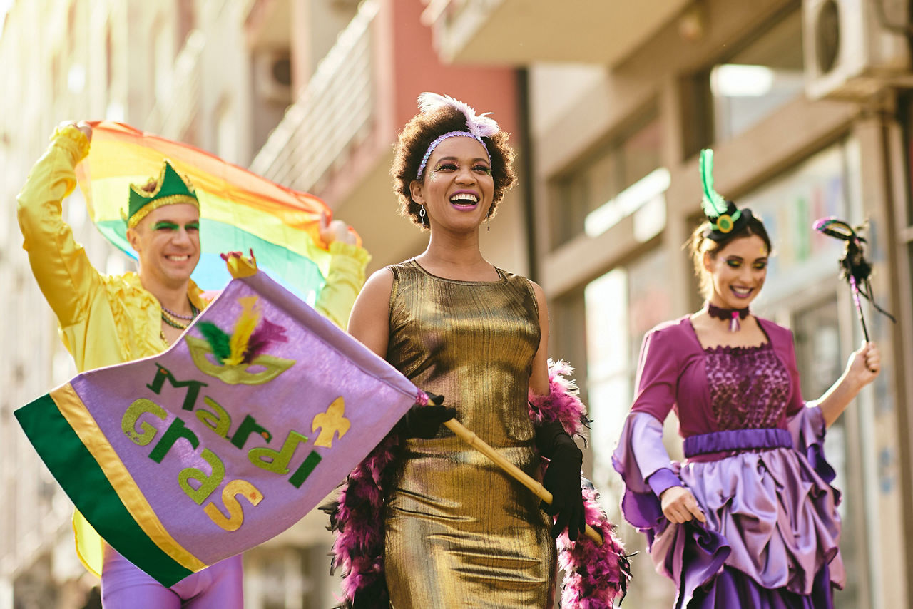 woman and her friends in carnival costumes and make-up on Mardi Gras parade.