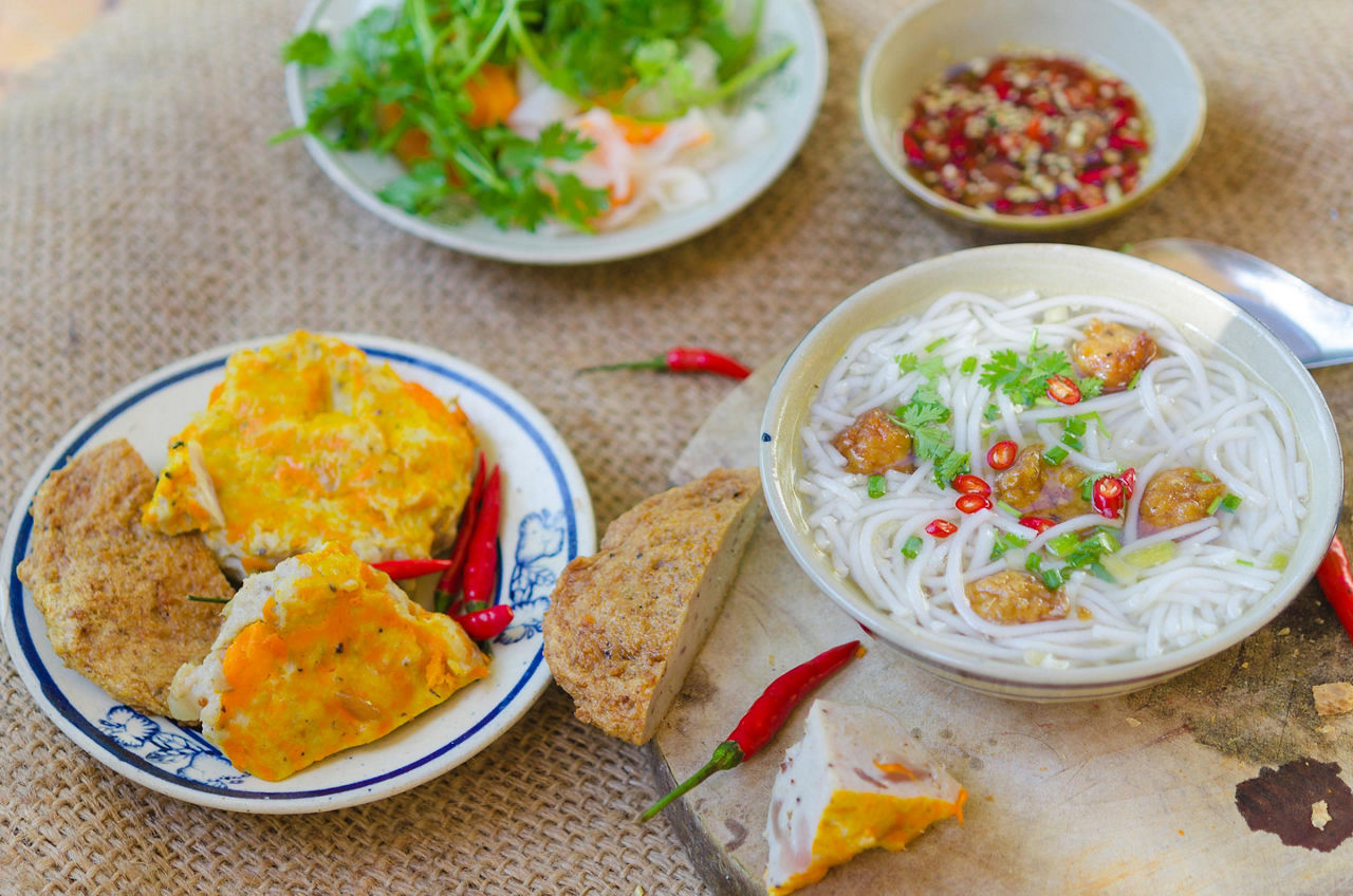 Banh Canh, one of most popular soup noodle in the seaside area with rice noodle, grilled fish, green onion and fish sauce