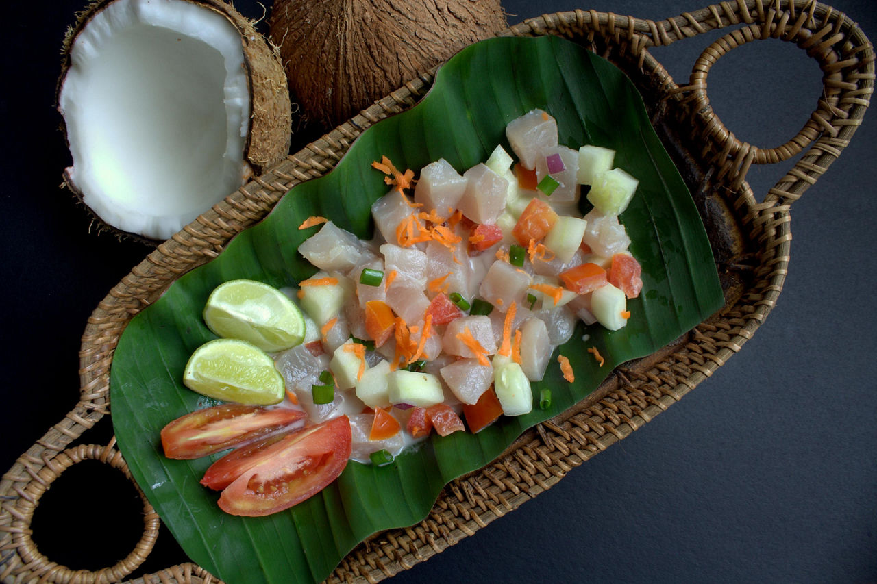 Polynesian authentic and famous dish -raw fish salad with cucumber, lime, tomato and coconut milk