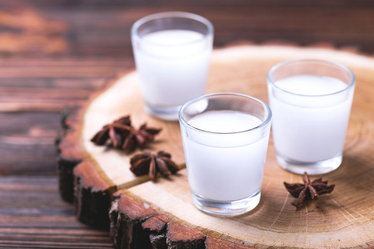 Alcohol drink Raki with anis on wooden board in Santorini, Greece