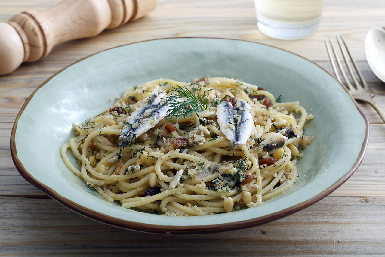 A bowl of pasta topped wit sardines