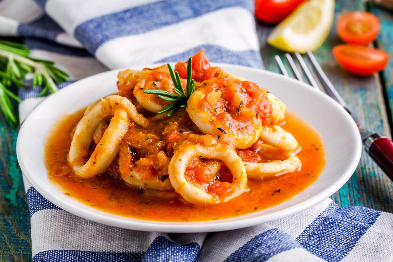 Squid rings in chili sauce served in a white bowl