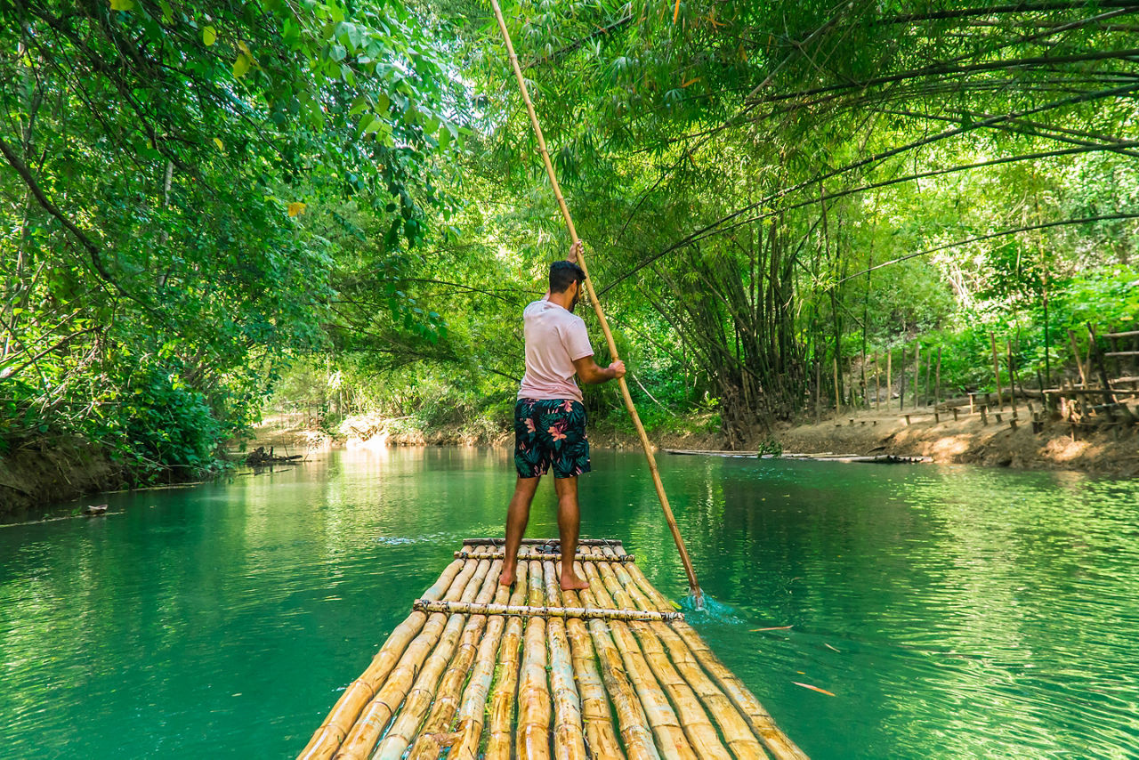 Traveler rowing bamboo raft, whilst on a cruise vacation in Montego Bay. Jamaica.