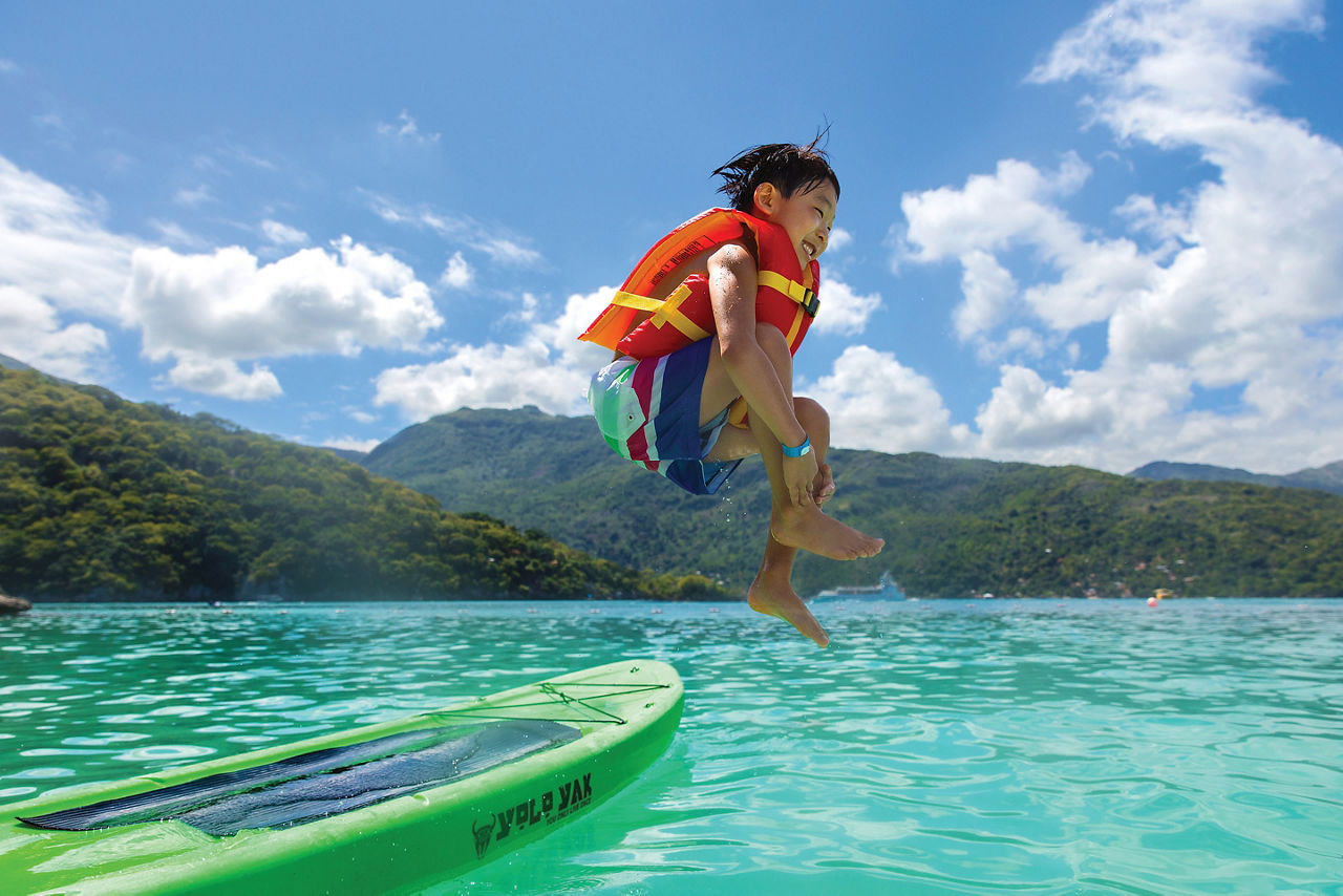 Young Boy Jumping inside Ocean after Kayaking