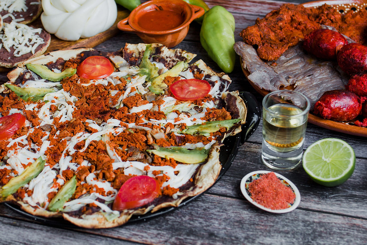 Traditional Oaxacan tlayuda topped with chorizo crumbles