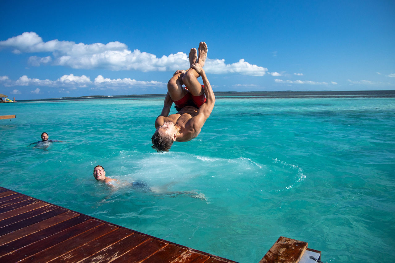 Coco Beach Club Man Jumping off Floating Cabana