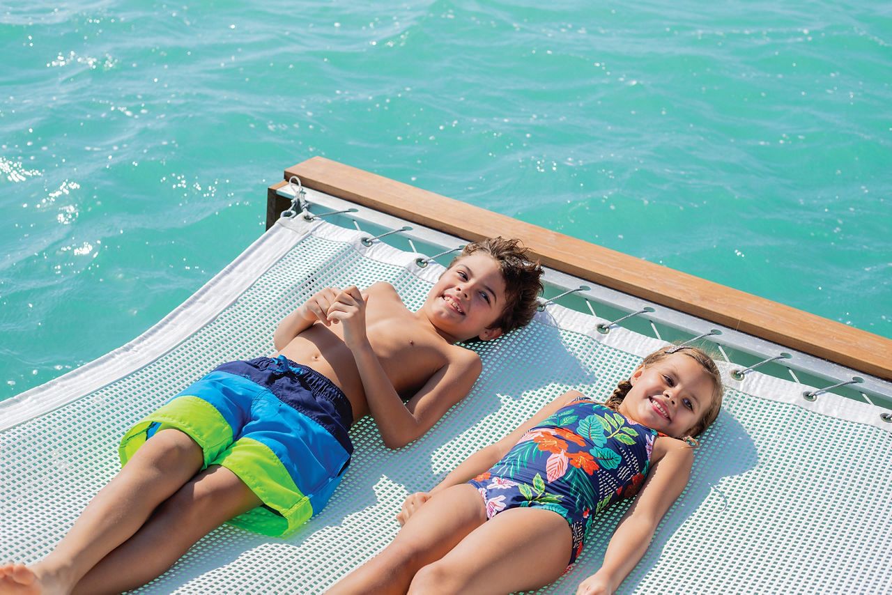 Coco Beach Club Floating Cabana Kids Laying on Hammock, Perfect Day at Coco Cay