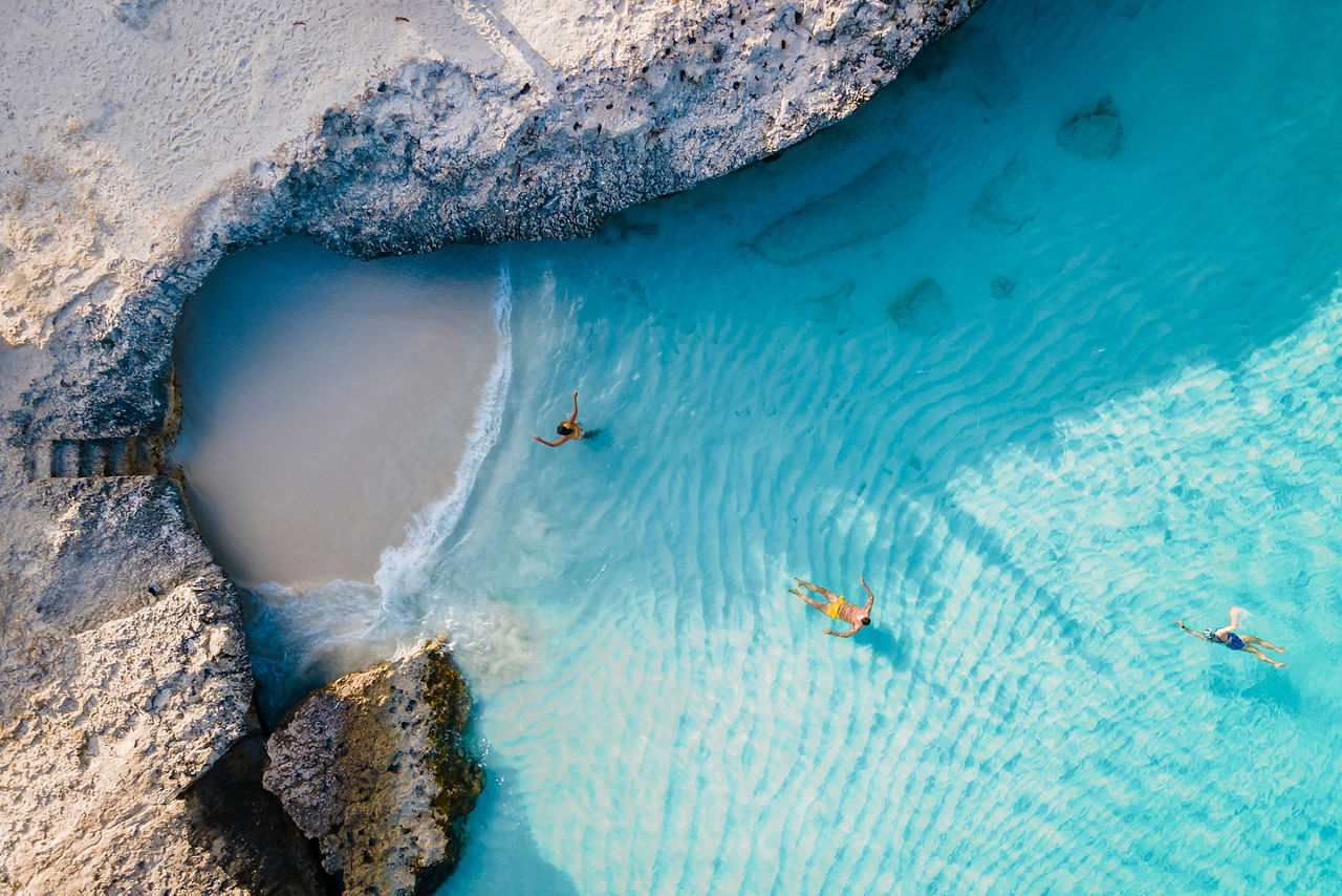 Tres Trapi Steps beach with vacation travelers relaxing. Aruba, The Caribbean.