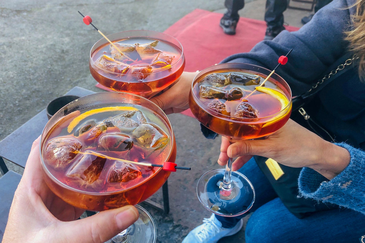 Three traveling friends holding glasses of vermouth. Spain.