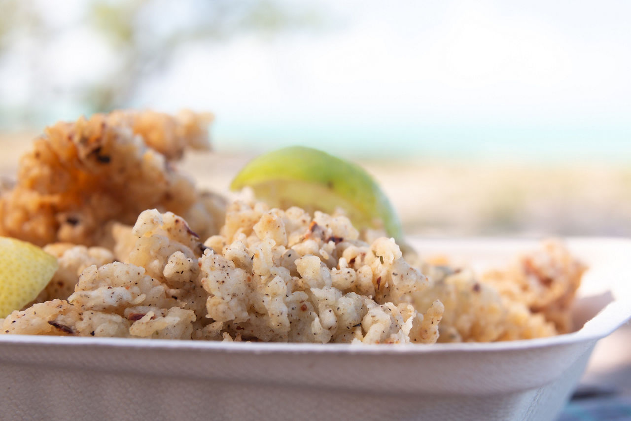 Closeup of a takeaway container filled with cracked conch, a tasty local seafood dish