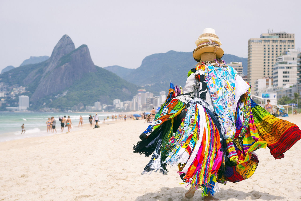 Beach vendor selling brightly colored kanga sarongs 