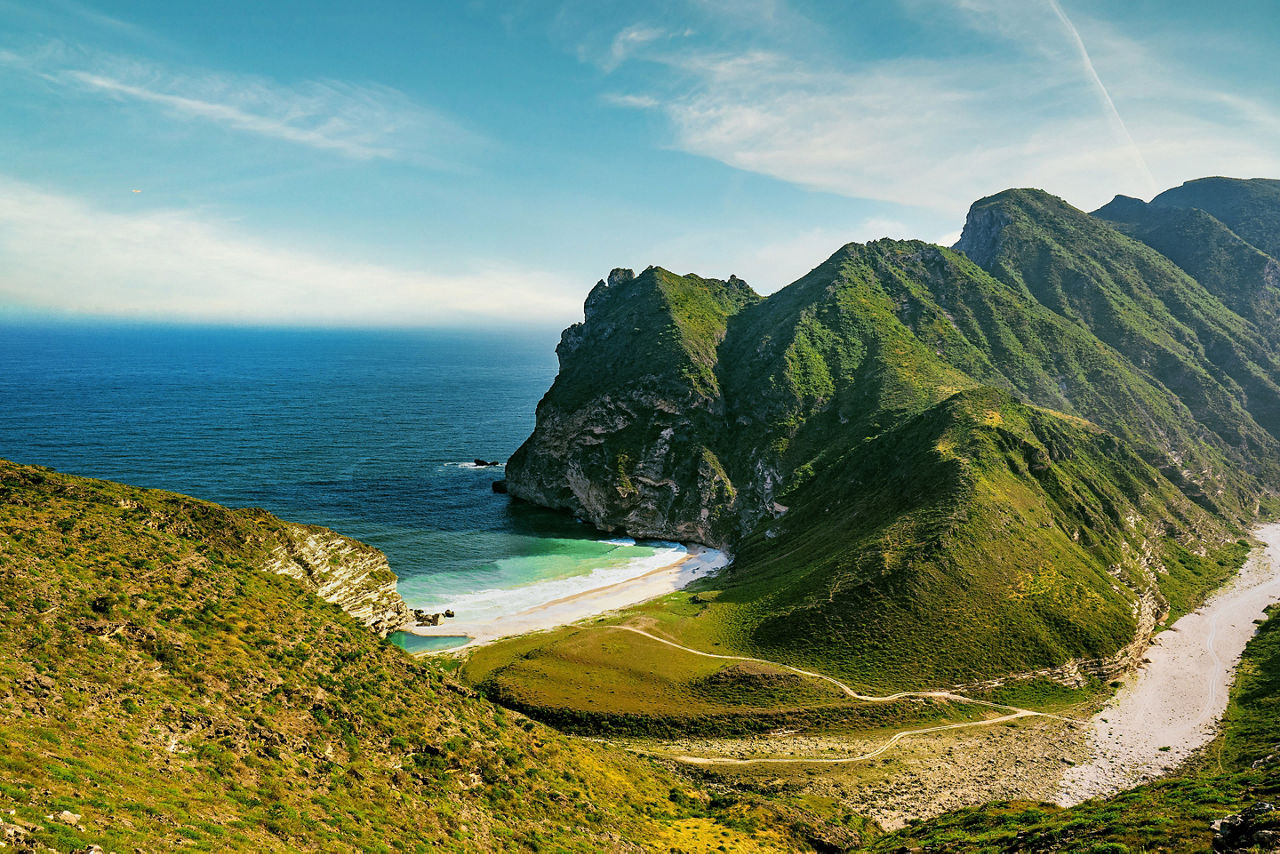 a view of mountains and sea in Al Mughsail Salalah, Sultanate of Oman