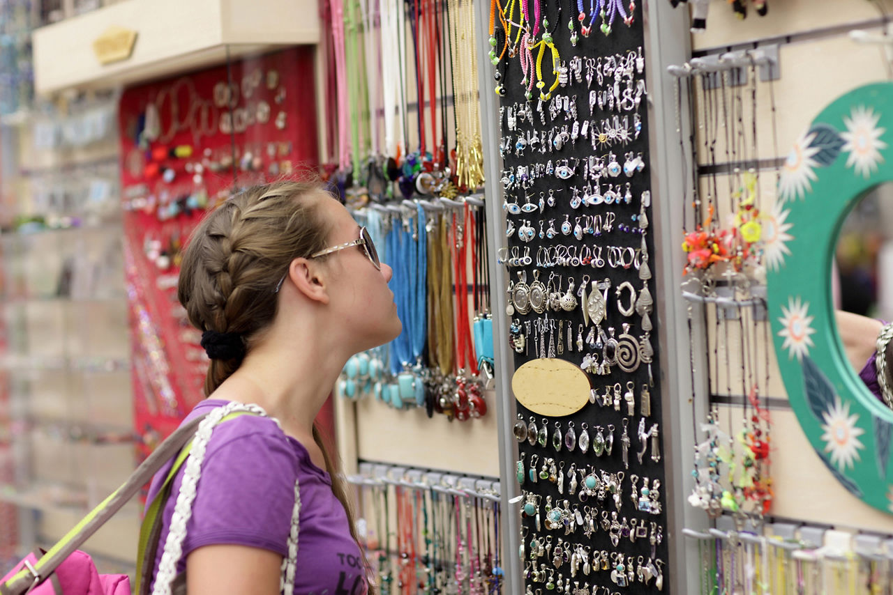 The girl is choosing souvenir at a greek market, Athens