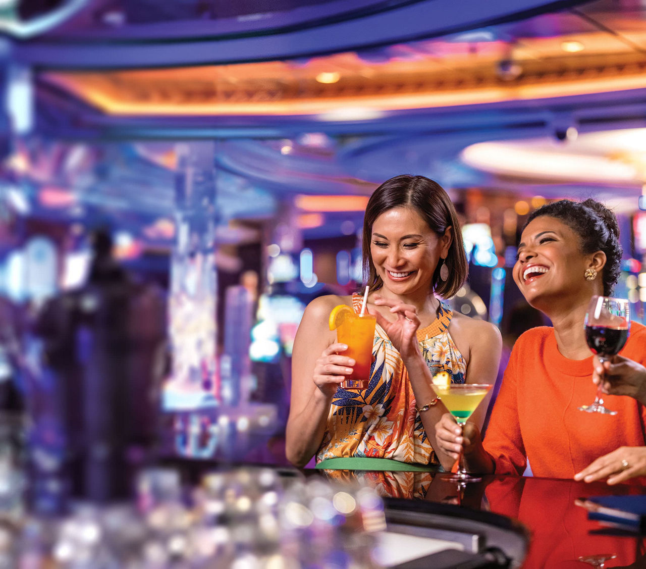 Two friends women who are enjoying drinks at casino on Royal Caribbean