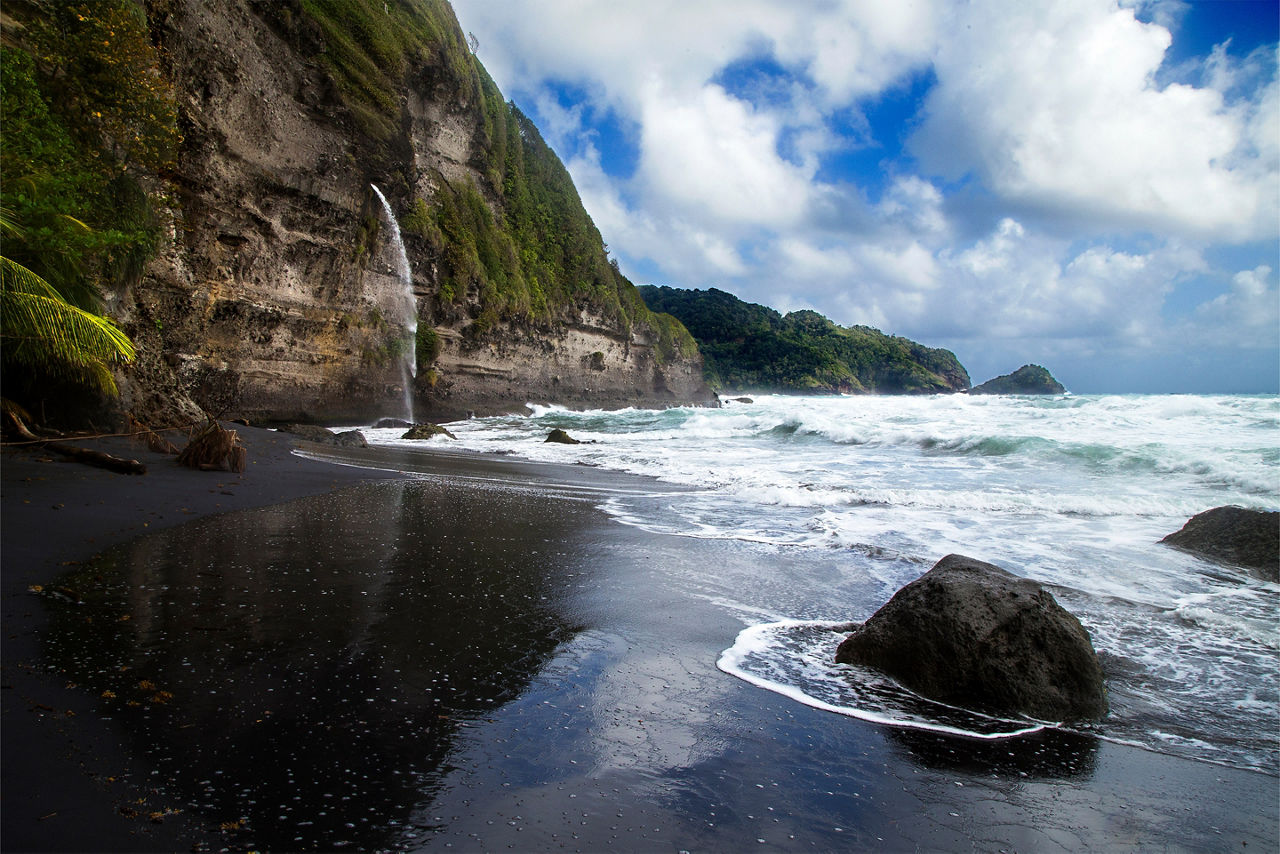  black sand beach with waterfall at Wavine Cyrique in Dominica. The Caribbean.