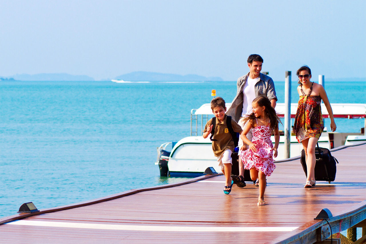 Family of 4 arriving at their vacation destination. The Caribbean.