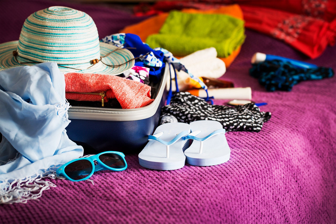 Suitcase being packed with clothing in cruise suite. The Caribbean.