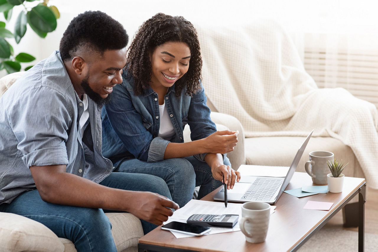 Smiling couple searching for black Friday vacation deals. The Caribbean.