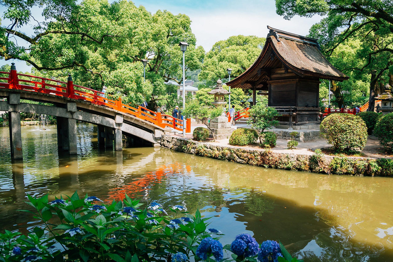 A red bridge over a water canal at the Dazaifu Tenmangu Shrine in Fukuoka, Japan