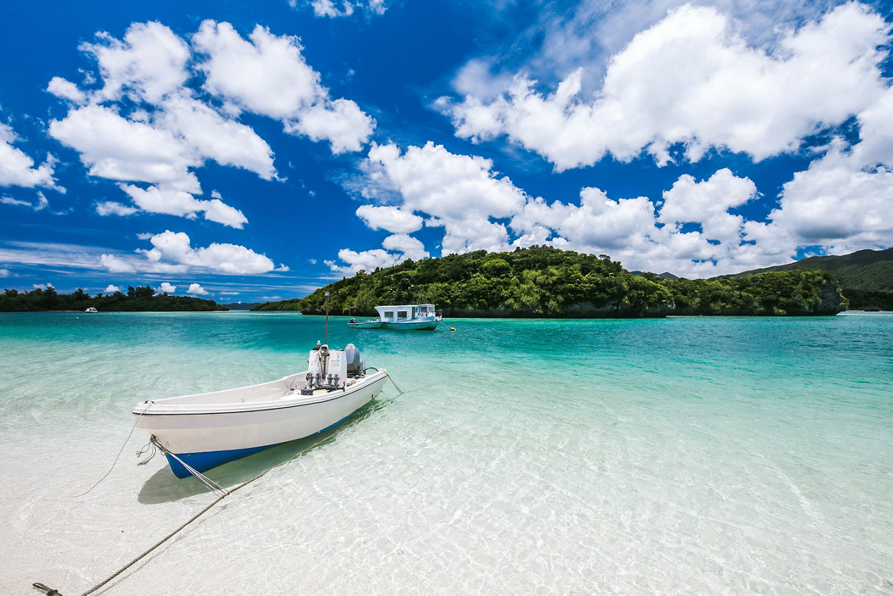 A few boats on the clear water of Kabira Bay in Ishigaki, Japan