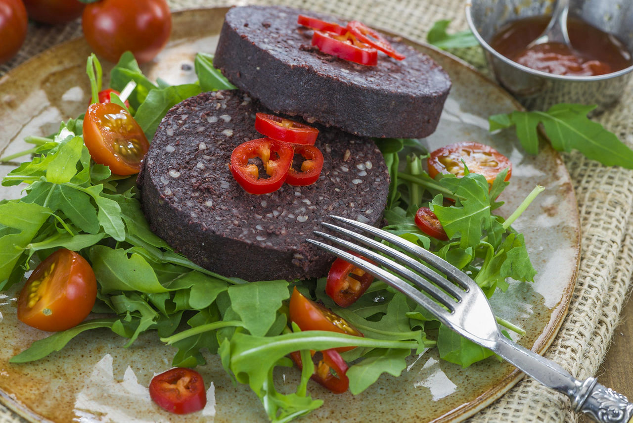 Sliced black pudding on a fresh salad