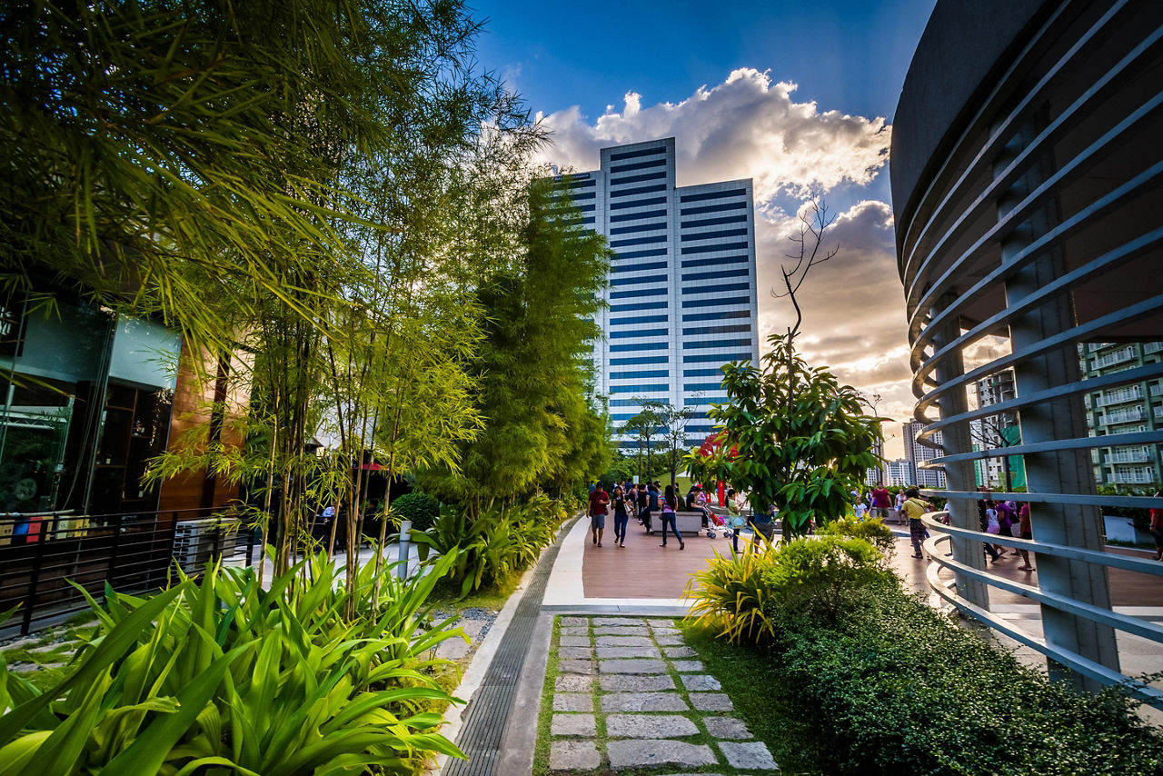 Garden and modern skyscraper in the city center of Manila, Philippines