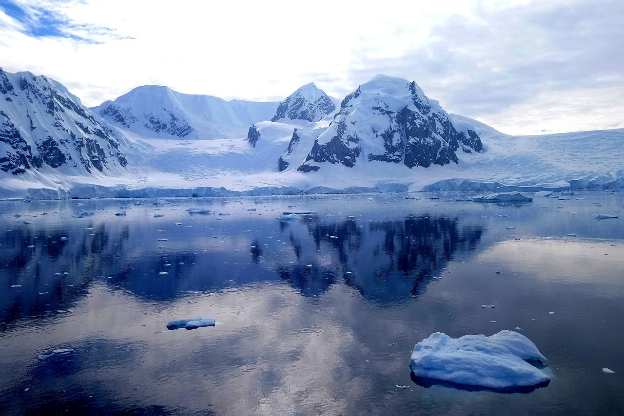 Extreme weather, scenic view of antarctica sea from a ship, snow and mountains.