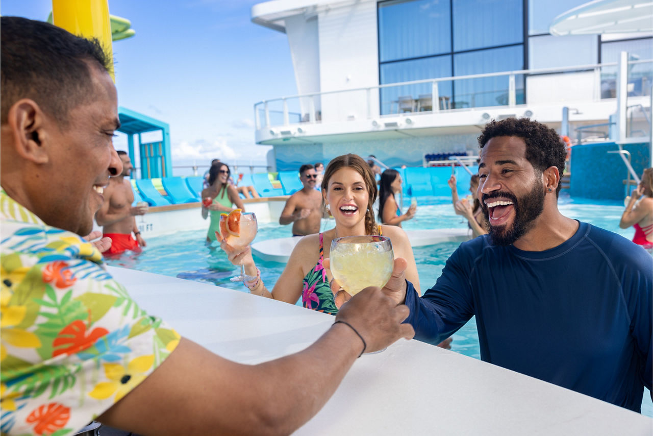 bartender handing couple cocktails swim and tonic pool star of the seas